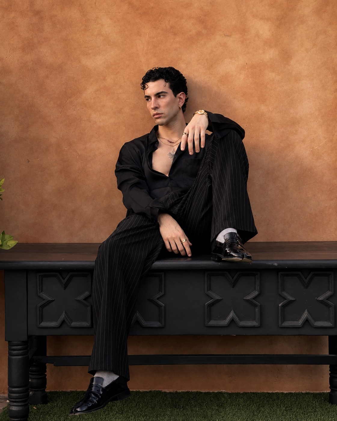 Luis Corrales seated in black tailoring for a Valentino Beauty perfume campaign